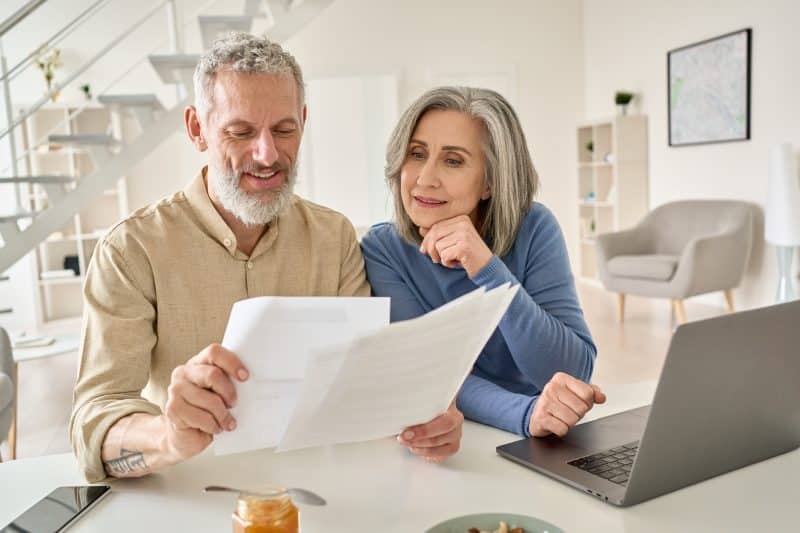 An elderly couple reviews forms about Medicare and SSDI.