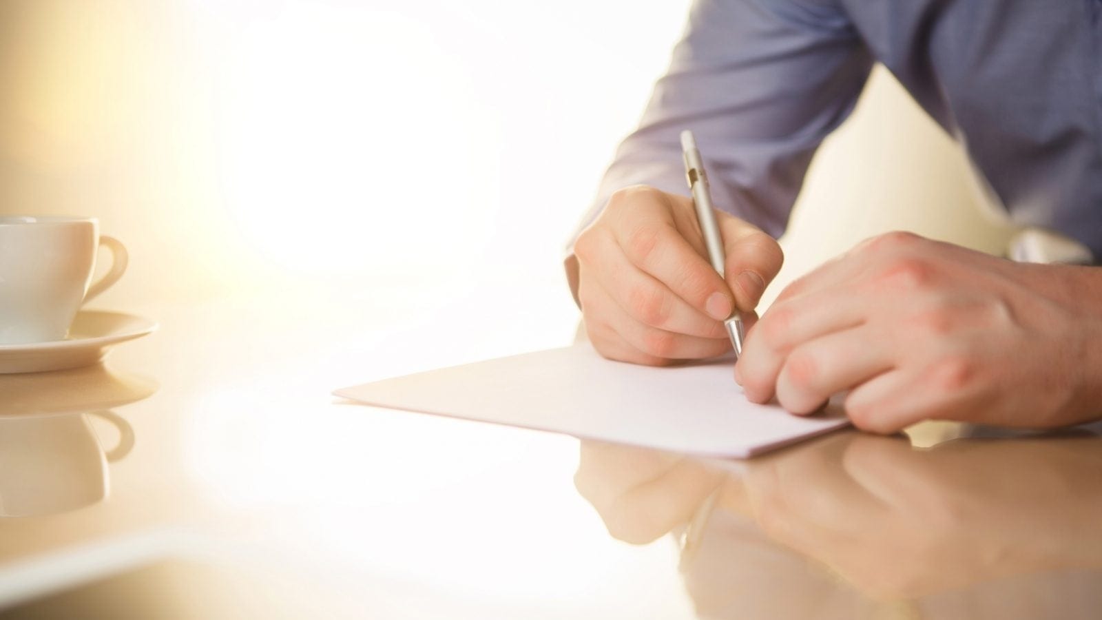 The male hands with a pen and the cup
