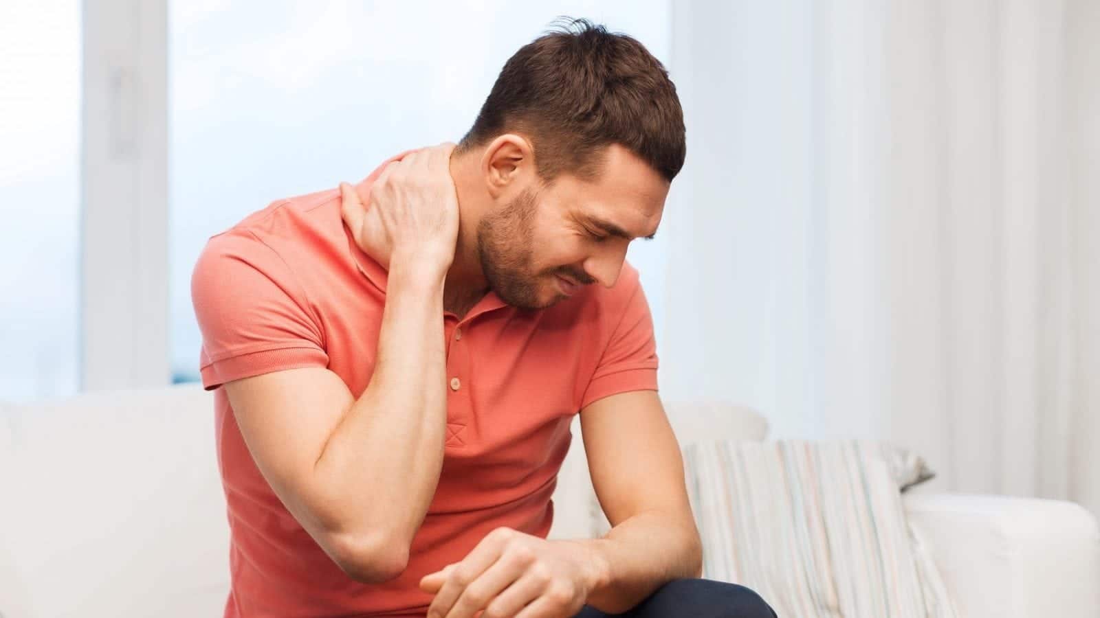 Unhappy man suffering from neck pain.