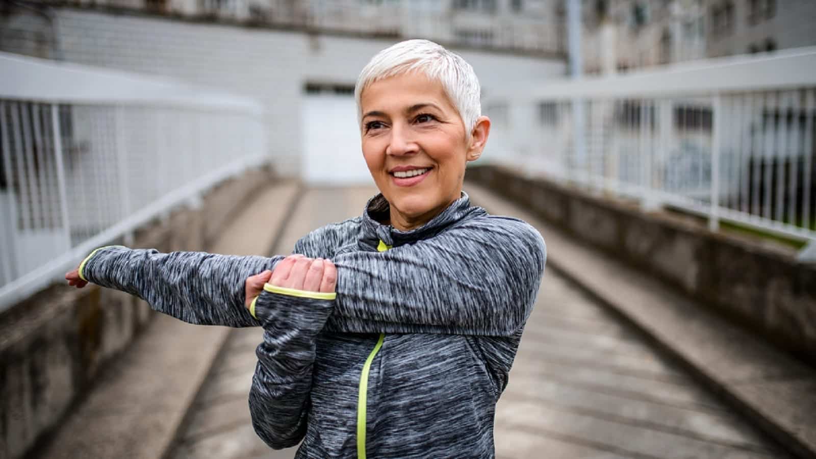 Mature Woman Stretching Before Running Outdoors