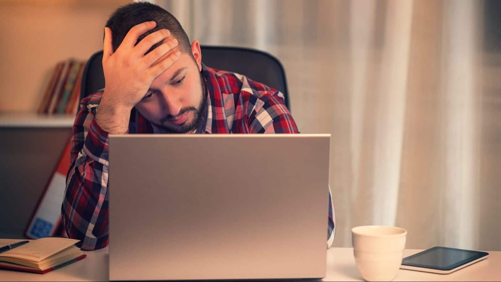 Young Man with migraine working at Home