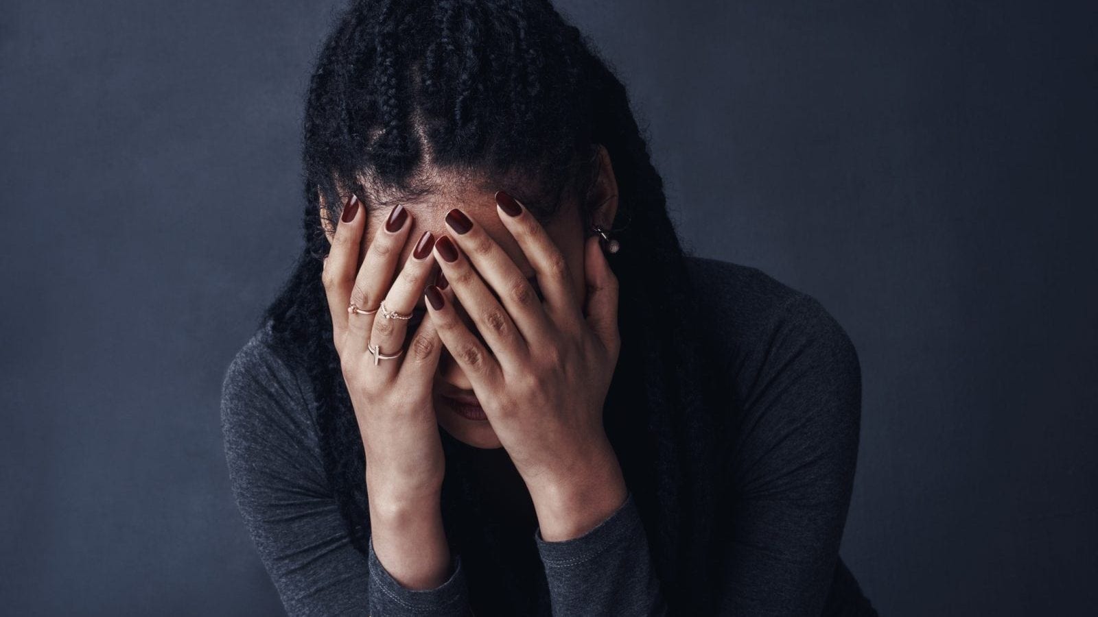 A young woman posing against a gray background