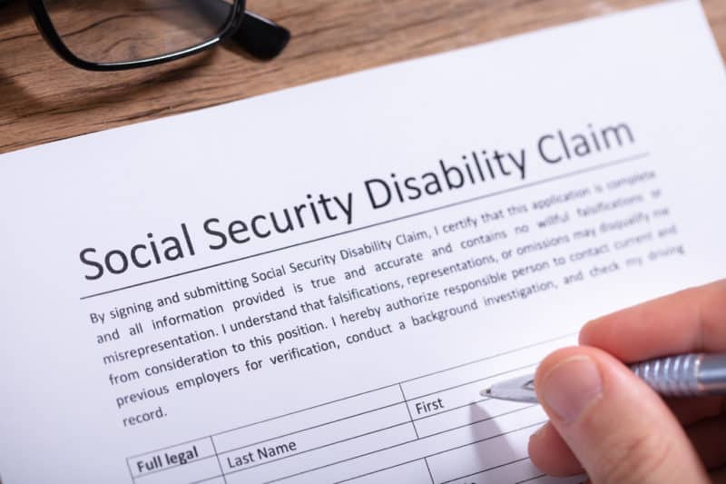 person filling out a Social Security Disability claim form